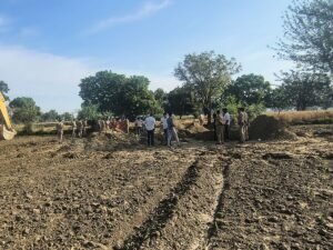 खेत में खुदाई करती टीम